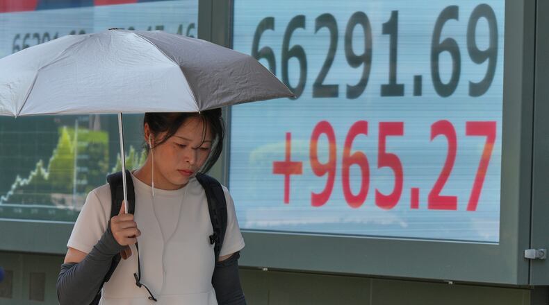 A person walks in front of an electronic stock board showing Japan's Nikkei index at a securities firm Thursday, Aug. 20, 2026, in Tokyo. (AP Photo/Eugene Hoshiko)