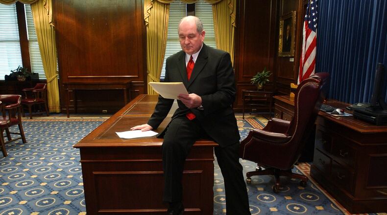 In this 2003 file photo, Gov. Sonny Perdue does his first official business as Georgia's new governor by reviewing some executive orders (which he signed later in the Senate chamber) in his new office at the Capitol.   After his inauguration ceremony at Philips, Perdue rode by car halfway to the Capitol and then walked the final distance with his wife, Mary. RICH ADDICKS/STAFF