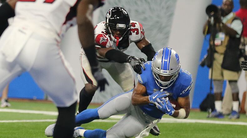 Golden Tate of the Lions catches the ball as Brian Poole of Falcons touches him and Tate's knee hits the ground during the fourth quarter at Ford Field on Sunday in Detroit. The play was originally ruled a touchdown with eight second left in the game. but was overturned after the officials viewed the play. With an ensuing 10-second runoff, the Falcons scored a 30-26 victory.