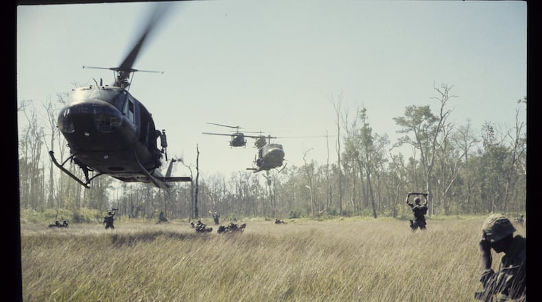 Huey helicopters swarm toward a landing zone in a photo by Tucker resident 1st Lt. James H. Holcombe Jr. The photo is part of “More Than Self: Living the Vietnam War,” a new exhibit at the Atlanta History Center. CONTRIBUTED BY JAMES H. HOLCOMBE JR.