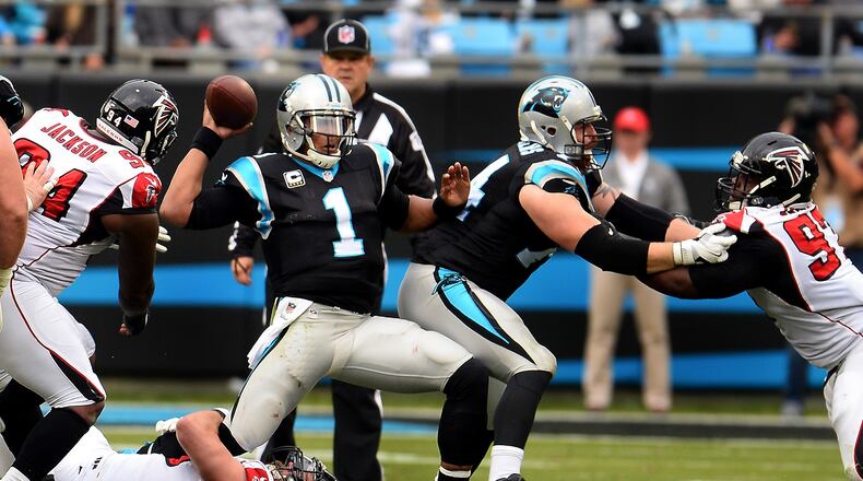 Carolina Panthers quarterback Cam Newton (1) fights to get off a pass as Atlanta Falcons defensive end Brooks Reid, bottom, wraps up Newton’s right leg in the third quarter on Saturday, Dec. 24, 2016, at Bank of America Stadium in Charlotte, N.C. The Falcons won, 33-16. (Jeff Siner/Charlotte Observer/TNS)