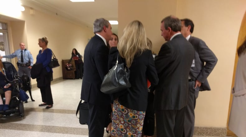 Rep. John Carson, R-Marietta (left), huddles with lobbyists under the Gold Dome after a hearing on House Bill 217, which attempted to increase the annual cap on tax credits for private school scholarships.