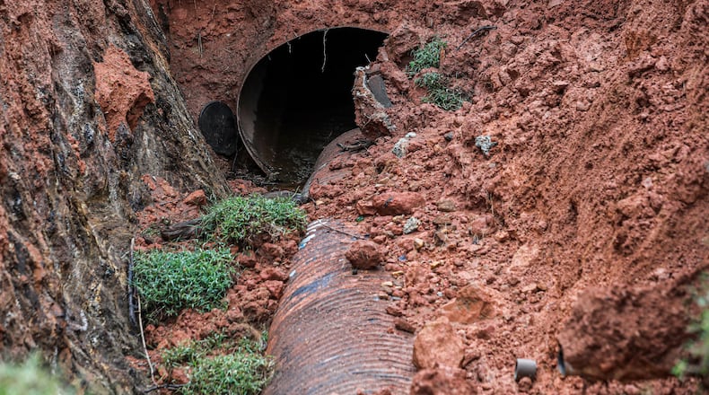 A sinkhole that appeared at a Marietta home last week had grown bigger on Friday. It was apparently caused when an underground pipe failed. (John Spink / John.Spink@ajc.com)