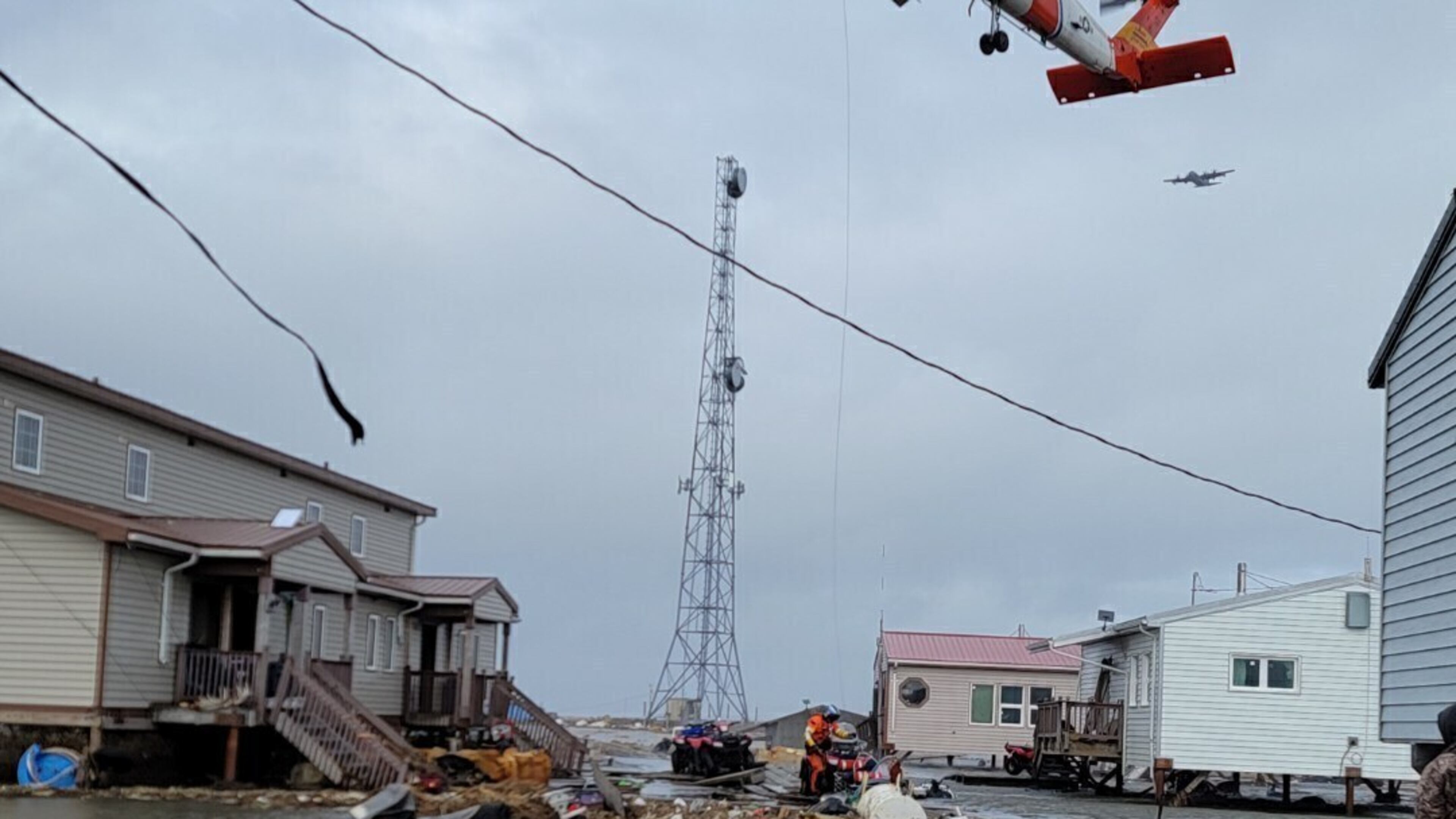 A helicopter responds after the remnant storms of Typhoon Halong devastated Kipnuk, Alaska, on Sunday, Oct. 12, 2025. (John Roland Carl II via AP)