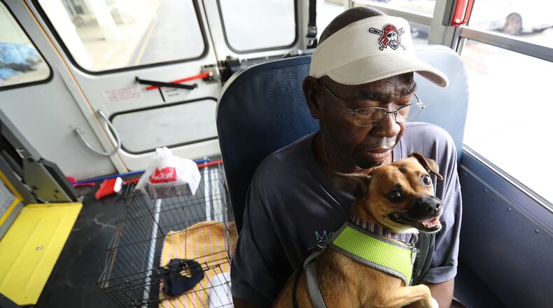 Brunswick resident Eddie Wright, 68, and his dog Vino wait Tuesday on one of the final buses at Lanier Plaza in the coastal city to evacuate from Hurricane Dorian to Columbus. Curtis Compton/ccompton@ajc.com