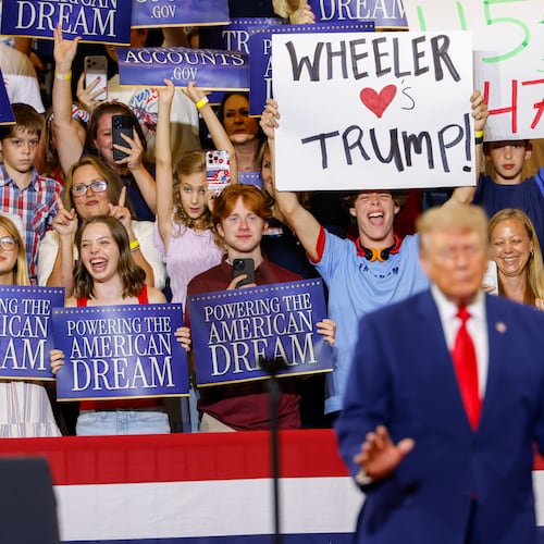 A support holds a sign that says “Wheeler Loves Trump” as President Donald Trump speaks at Wheeler High School in Marietta on July 22, 2026. (Arvin Temkar/AJC)