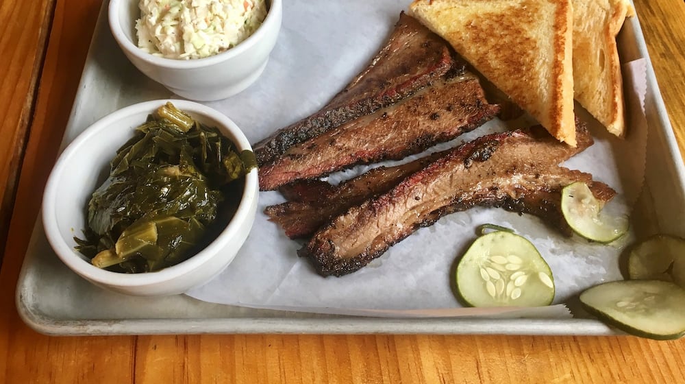 The Beef Brisket Plate from the Nest with a side of coleslaw and collard greens. The restaurant also offers plates of pulled pork, a half-chicken and chicken tenders. Each comes with two sides, house pickles and Texas toast. HOLLY STEEL / HSTEEL@AJC.COM