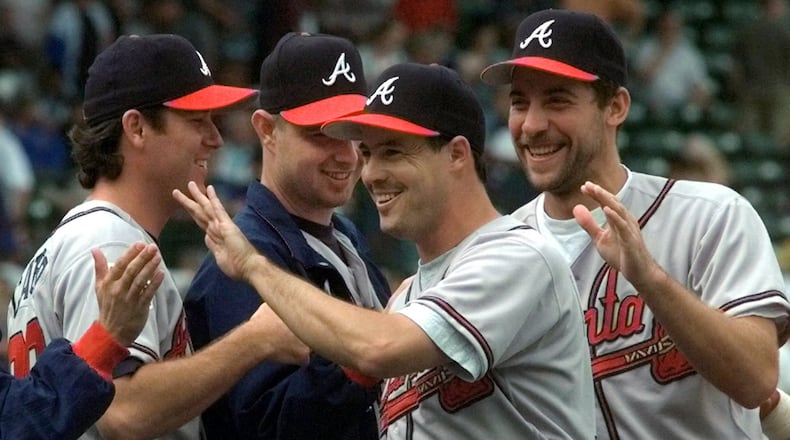 Braves pitchers Mike Cather (from left), Alan Embree and John Smoltz (right), congratulate Greg Maddux (center) after he threw a five hitter Tuesday, July 22, 1997, against the Chicago Cubs in Chicago. The Braves defeated the Cubs 4-1 in the first game of a doubleheader. (Michael S. Green/AP)