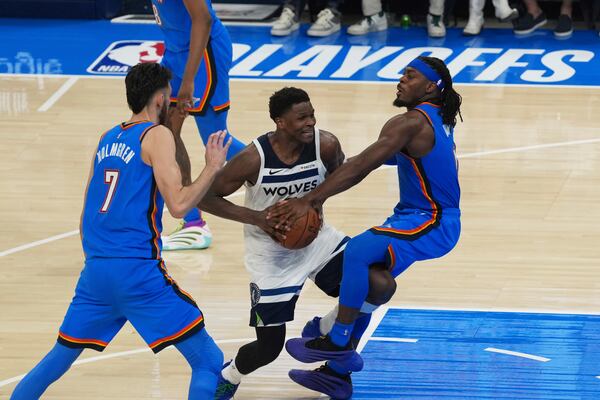 Minnesota Timberwolves guard Anthony Edwards (5) works toward the basket as Oklahoma City Thunder forward Chet Holmgren (7) and guard Luguentz Dort (5) defend during the second half of Game 5 of the Western Conference finals of the NBA basketball playoffs, Wednesday, May 28, 2025, in Oklahoma City. (AP Photo/Kyle Phillips)
