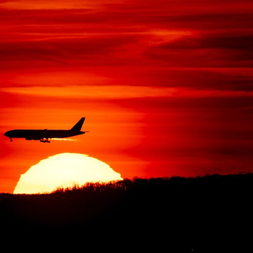 FILE - A passenger jet on approach to Newark Liberty International Airport flies over the setting sun in Newark, N.J., March 27, 2019. (AP Photo/J. David Ake, File)