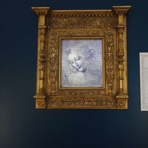 Primo Maronati holds a certificate next to a digital version of Leonardo Da Vinci's portrait, "La Scapiliata, Lady with Disheveled Hair," at the Brera Art Gallery in Milan, Italy, Monday, Nov. 24, 2025. (AP Photo/Antonio Calanni)