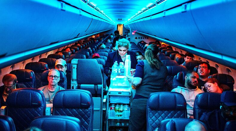 Flight attendants serve refreshments on a Delta Airlines flight from Hartsfield-Jackson International Airport on Aug. 1, 2022 in Atlanta, Georgia. Over the last dozen years, airlines have found a new way to drive up revenue: squeezing more seats into each plane. (Kent Nishimura/Los Angeles Times/TNS)