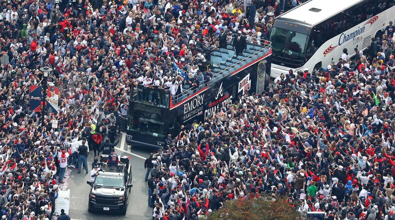 110521 ATLANTA: Braves players hoist the Commissioner's Trophy from the top of a double decker bus surrounded by thousands of fans as they arrive in the Battery outside Truist Park while the Atlanta Braves host a World Series Championship Parade and celebration on Friday, Nov. 5, 2021, in Atlanta. “Curtis Compton / Curtis.Compton@ajc.com”