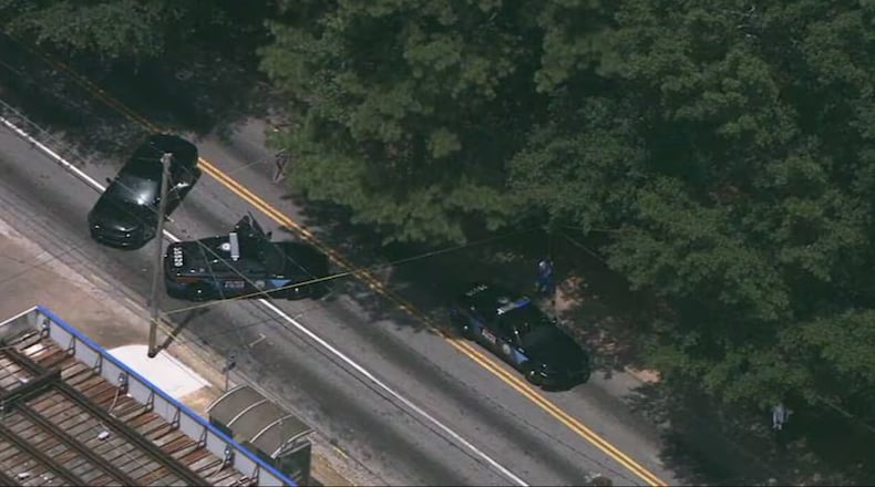 Atlanta police squad cars gathered at the intersection of Cleveland Avenue and Browns Mill Road after three people were found shot in the area.