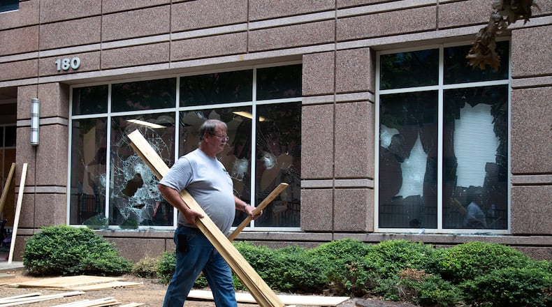 Workers make repairs to the Department of Homeland Security and Immigration and Customs Enforcement field offices in Atlanta on July 26, 2020, a day after the building was vandalized by protesters.