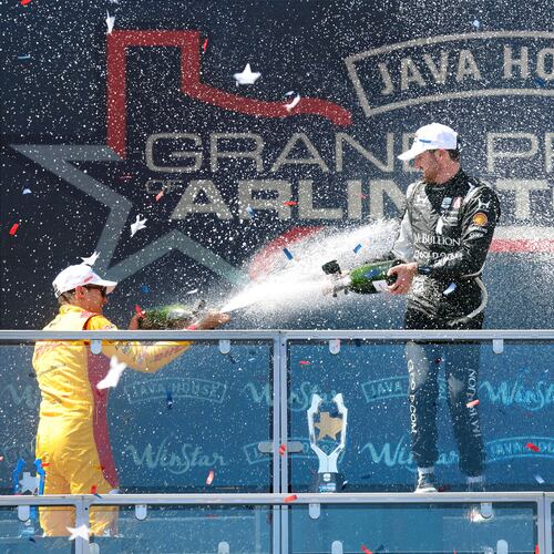 Grand Prix of Arlington winning driver Kyle Kirkwood of Andretti Global, center, is doused with champagne by second place finisher Alex Palou, left, and third place finisher Will Power following at the Grand Prix of Arlington auto race, Sunday, March 15, 2026, in Arlington, Texas. (Tom Fox/The Dallas Morning News via AP)