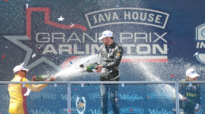Grand Prix of Arlington winning driver Kyle Kirkwood of Andretti Global, center, is doused with champagne by second place finisher Alex Palou, left, and third place finisher Will Power following at the Grand Prix of Arlington auto race, Sunday, March 15, 2026, in Arlington, Texas. (Tom Fox/The Dallas Morning News via AP)
