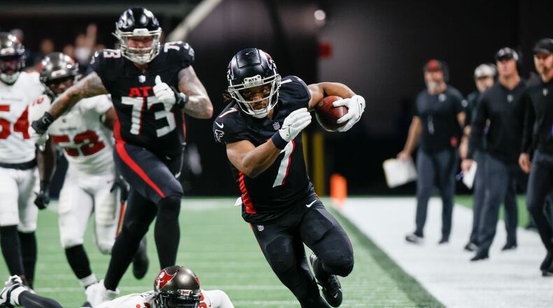 Atlanta Falcons running back Bijan Robinson (7) breaks the defense line during the second half of an NFL football game against the Tampa Bay Buccaneers on Sunday, Dec. 10, 2023, at Mercedes-Benz Stadium in Atlanta. 
Miguel Martinez/miguel.martinezjimenez@ajc.com