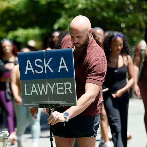 Atlanta attorney Cody Randall sets up his station on the Beltline near Krog Street Market, where he is well known for providing free legal advice to the public, on Sunday, May 3, 2026. Randall has 1.5 million followers on social media, where he posts clips of his conversations. (Miguel Martinez/AJC)