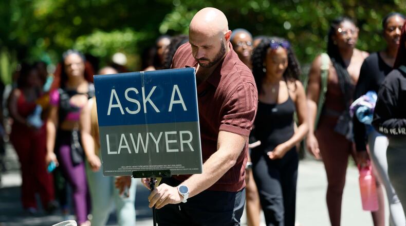 Atlanta attorney Cody Randall sets up his station on the Beltline near Krog Street Market, where he is well known for providing free legal advice to the public, on Sunday, May 3, 2026. Randall has 1.5 million followers on social media, where he posts clips of his conversations. (Miguel Martinez/AJC)