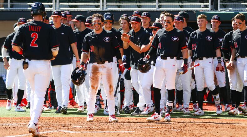 Members of the Georgia baseball team celebrate second baseman LJ Talley (2) as he reaches home Dayton Saturday, Feb. 16, 2019, at Foley Field in Athens.
