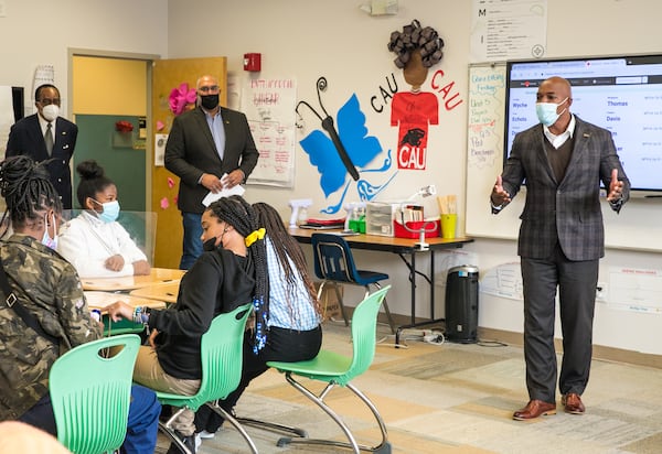 Members of 100 Black Men, including Joshua Byrd, leading the program, offer mentoring and an anti-gun violence program to students at Ivy Prep Academy on Wednesday, March 16, 2022.  The program provides several weeks of after-school education in conflict resolution, personal choices, social media pitfalls and offers a student billboard competition while spreading awareness of gun violence.   (Jenni Girtman for The Atlanta Journal Constitution)