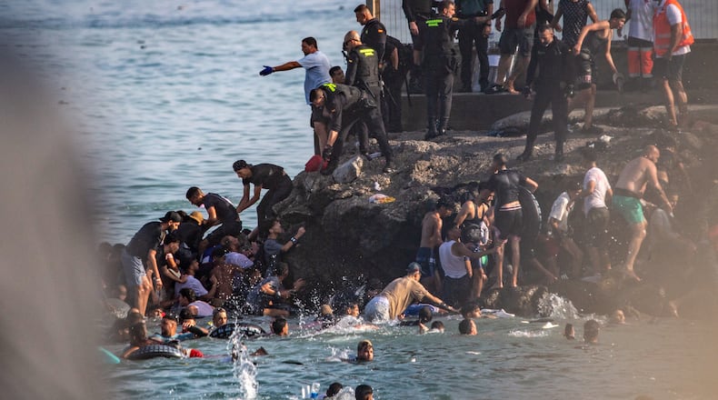 Migrants try to cross from Morocco into the Spanish enclave of Ceuta, Thursday, July 30, 2026. (AP Photo/Antonio Sempere)