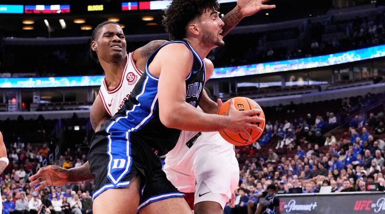 Duke forward Cameron Boozer, right, drives to the basket as Arkansas forward Nick Pringle, left, defends during the first half of an NCAA college basketball game in the CBS Sports Thanksgiving Classic tournament Thursday, Nov. 27, 2025, in Chicago. (AP Photo/Nam Y. Huh)