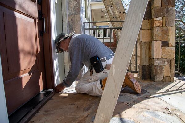 360 Painting of North Georgia painter Rafael Bail uses painters plastic and painters tape to prepare a house for painting in Atlanta’s Virginia Highlands community, Tuesday, March 9, 2021. (Alyssa Pointer / Alyssa.Pointer@ajc.com)