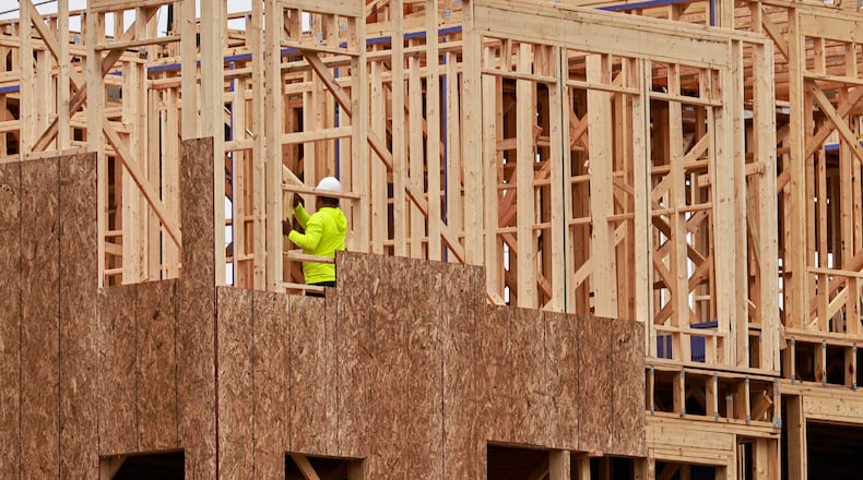 A worker continues construction on the foundation of a luxury townhouse at Foundry by JW Homes in Alpharetta. Construction lagged for years after the 2007-09 recession and has never caught up with metro Atlanta's population growth. Moreover, few homes are priced for first-time buyers. (Natrice Miller/natrice.miller@ajc.com)