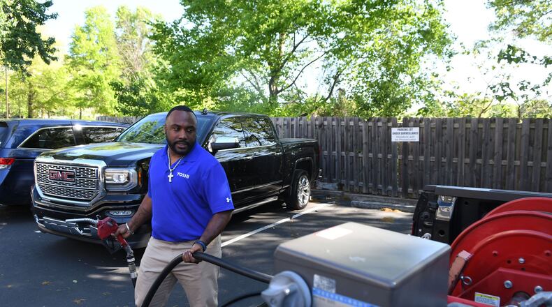 Brian Glanton, a field technician and supervisor for Yoshi, fills up a gas tank in an Atlanta area parking lot. Yoshi, a San Francisco venture backed by Exxon and GM, is doubling down on its operations in metro Atlanta, where it delivers fuel directly to customers’ vehicles at work or home. (Rebecca Breyer)