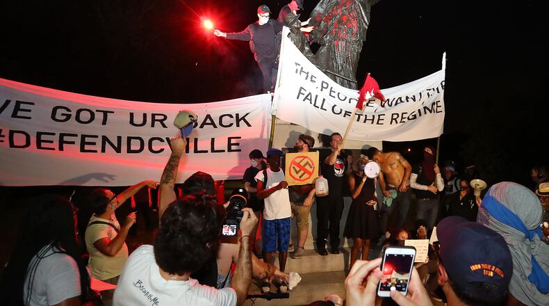 Protesters climbed the Peace Monument in Piedmont Park, spray painted it and tried tearing it down. The structure was erected in 1911 to champion unity and reconciliation. AJC photo: Curtis Compton