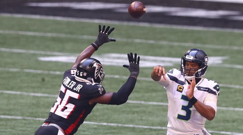 Seattle Seahawks quarterback Russell Wilson completes a first-down pass under pressure from Atlanta Falcons defensive end Dante Fowler during the second half Sunday, Sept. 13, 2020 in Atlanta. (Curtis Compton / Curtis.Compton@ajc.com)