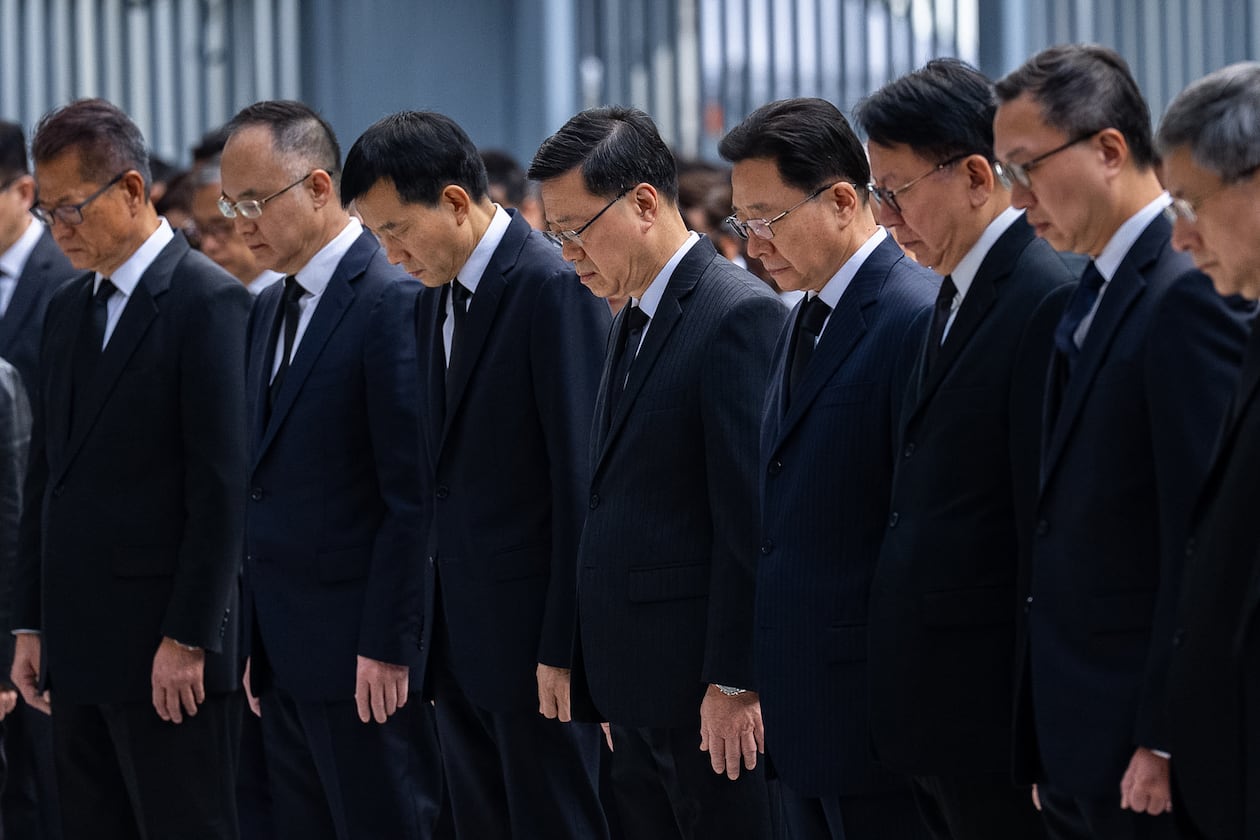 Hong Kong Chief Executive John lee, center and other officers observe a moment of silence for the victims of the deadly fire that started Wednesday at Wang Fuk Court, a residential estate in the Tai Po district of Hong Kong's New Territories, Saturday, Nov. 29, 2025. (AP Photo/Chan Long Hei)