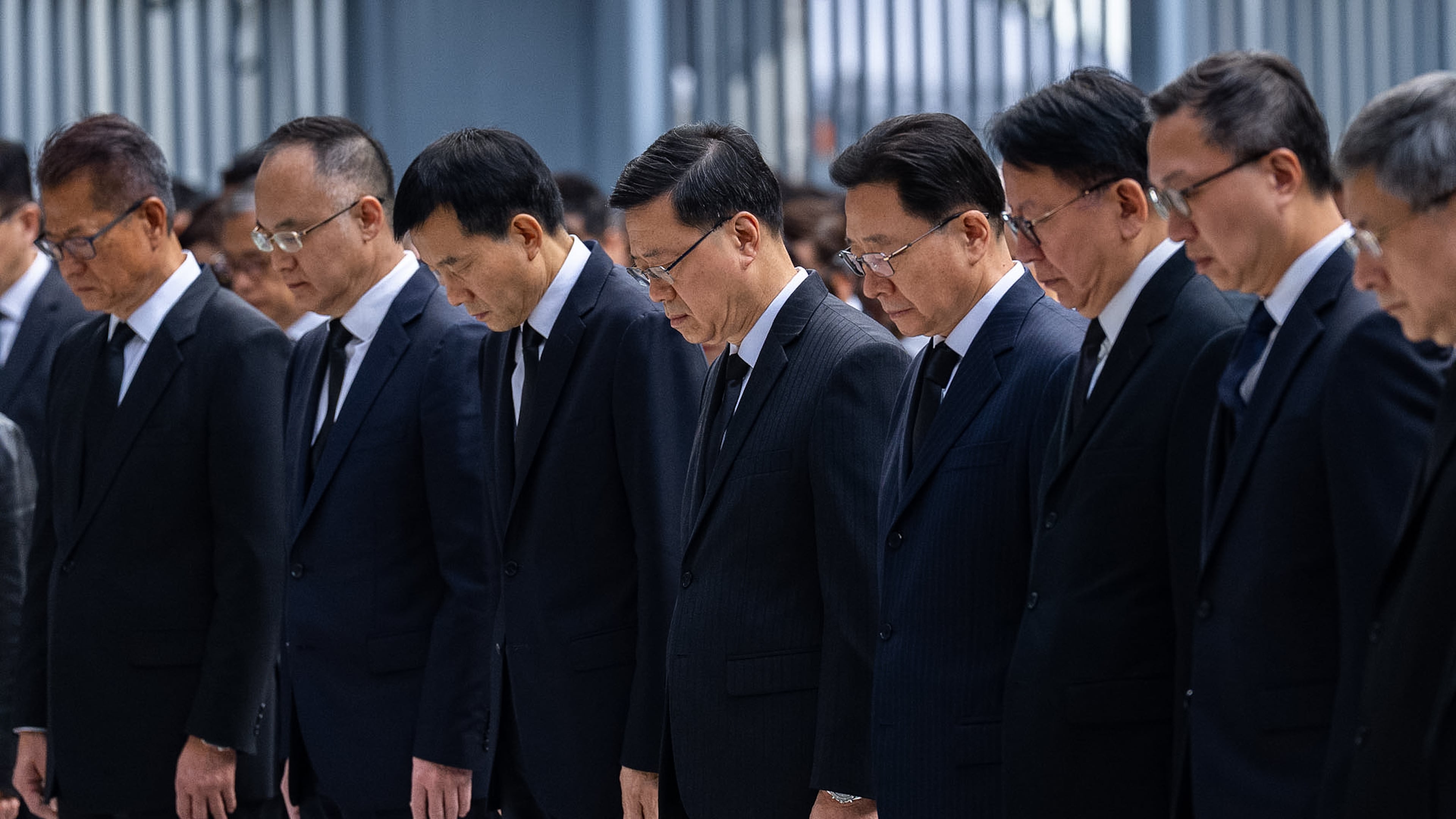 Hong Kong Chief Executive John lee, center and other officers observe a moment of silence for the victims of the deadly fire that started Wednesday at Wang Fuk Court, a residential estate in the Tai Po district of Hong Kong's New Territories, Saturday, Nov. 29, 2025. (AP Photo/Chan Long Hei)