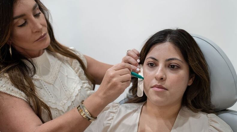 Daniela Ezratty (left), owner of Virginia-Highland-based Ezratty Integrative Aesthetics, meets with a client to discuss facial balancing. (Courtesy of Ezratty Integrative Aesthetics)