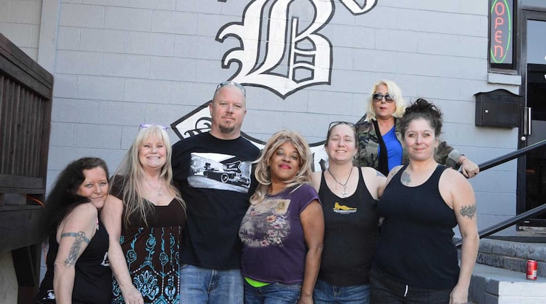Carlos Bickers, owner of B3 Bar and Grill in Austell, poses with some of the Clermont Lounge's exotic dancers Feb. 26, 2017. They were at B3 for a car wash fundraiser while the iconic Atlanta dive bar undergoes longer-than-expected renovations.