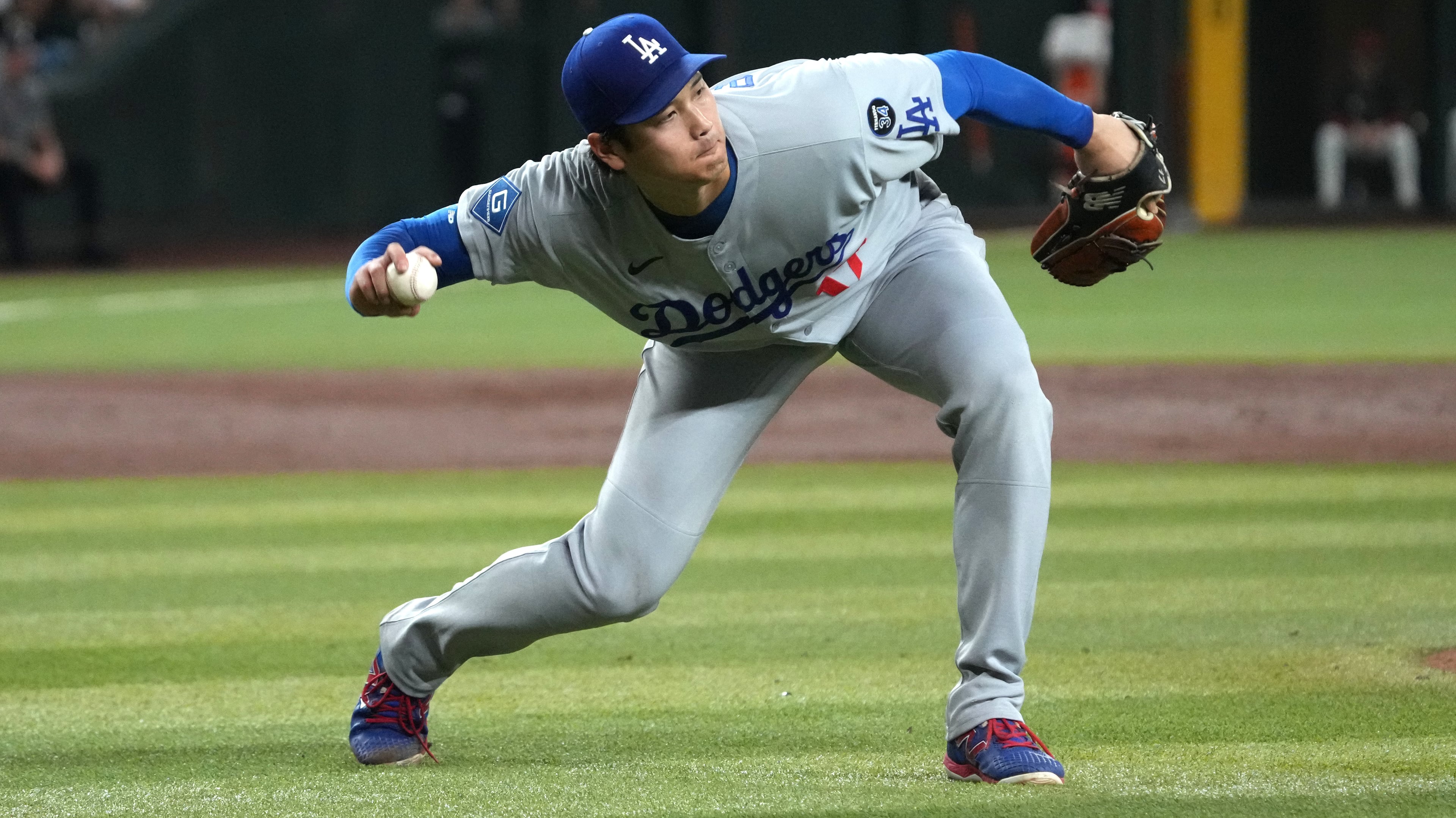 Los Angeles Dodgers pitcher Shohei Ohtani fields the ball hit by Arizona Diamondbacks' Alek Thomas in the third inning of a baseball game, Tuesday, Sept. 23, 2025, in Phoenix. (AP Photo/Rick Scuteri)