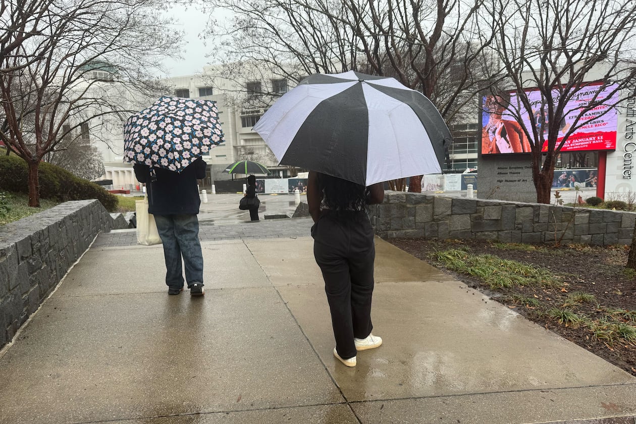 Visitors to the High Museum of Art walk in the rain as a storm moves through Midtown on Saturday, Jan. 10, 2026, in Atlanta. (James Bennett/AJC)