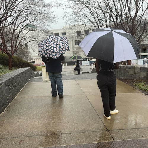 Visitors to the High Museum of Art walk in the rain as a storm moves through Midtown on Saturday, Jan. 10, 2026, in Atlanta. (James Bennett/AJC)