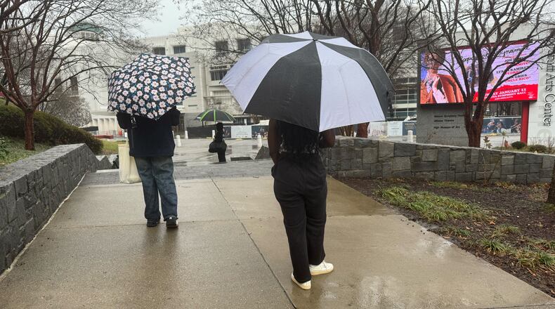 Visitors to the High Museum of Art walk in the rain as a storm moves through Midtown on Saturday, Jan. 10, 2026, in Atlanta. (James Bennett/AJC)