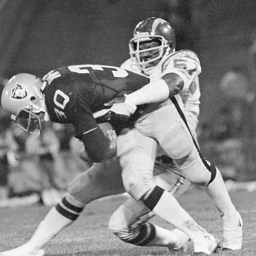 FILE - Mark van Eeghen of the Oakland Raiders is stopped by Woodrow Lowe of the San Diego Chargers after a nine-yard gain during the second period of their game at the Oakland, Coliseum in Oakland, Calif., Oct. 25, 1979. (AP Photo, File)