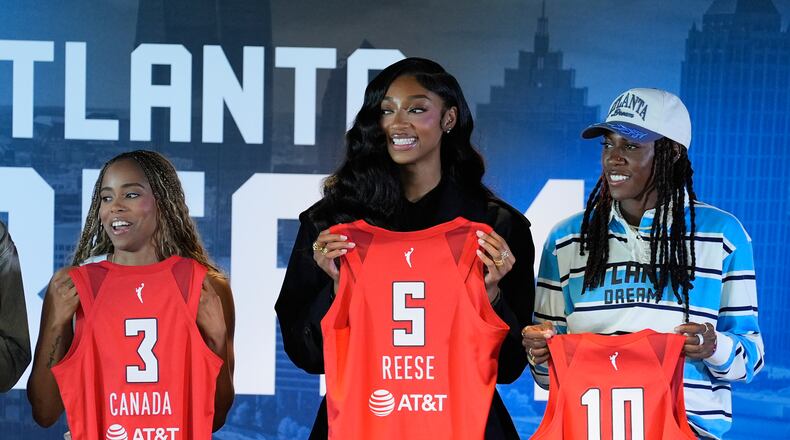 Atlanta Dream's Jordin Canada, Angel Reese And Rhyne Howard hold up their jerseys during a news conference by the Atlanta Dream on Friday, April 17, 2026, in Atlanta. (AP Photo/Brynn Anderson)
