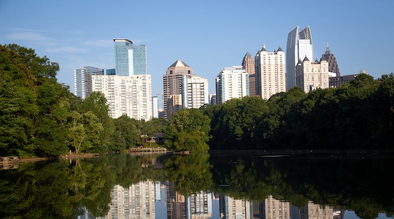 The city's skyline is reflected in the water on a quiet Friday morning at Piedmont Park July 17, 2020. STEVE SCHAEFER FOR THE ATLANTA JOURNAL-CONSTITUTION