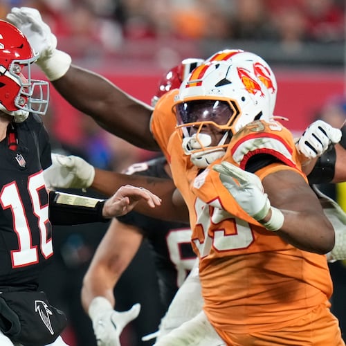 Falcons quarterback Kirk Cousins (left) is pressured by Buccaneers defensive end Elijah Roberts on Thursday, Dec. 11, 2025, in Tampa, Fla. For the third time in three starts with the Falcons, Cousins guided them to victory. (Chris O'Meara/AP)