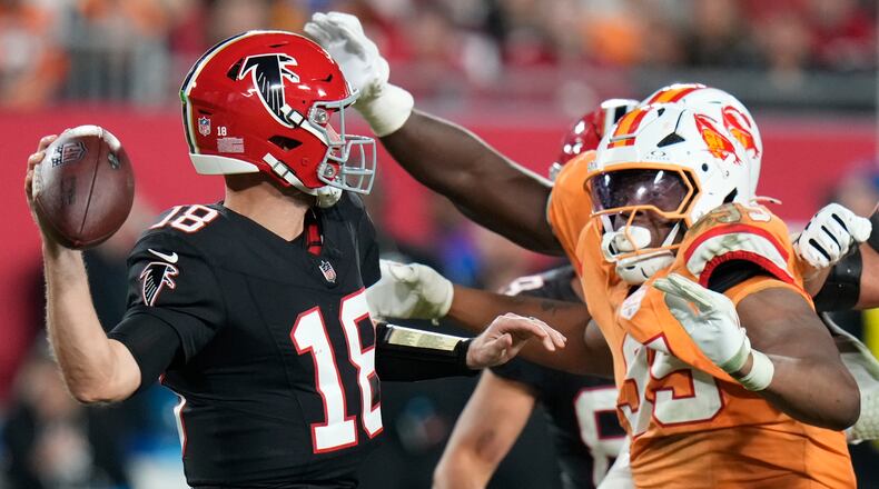 Falcons quarterback Kirk Cousins (left) is pressured by Buccaneers defensive end Elijah Roberts on Thursday, Dec. 11, 2025, in Tampa, Fla. For the third time in three starts with the Falcons, Cousins guided them to victory. (Chris O'Meara/AP)