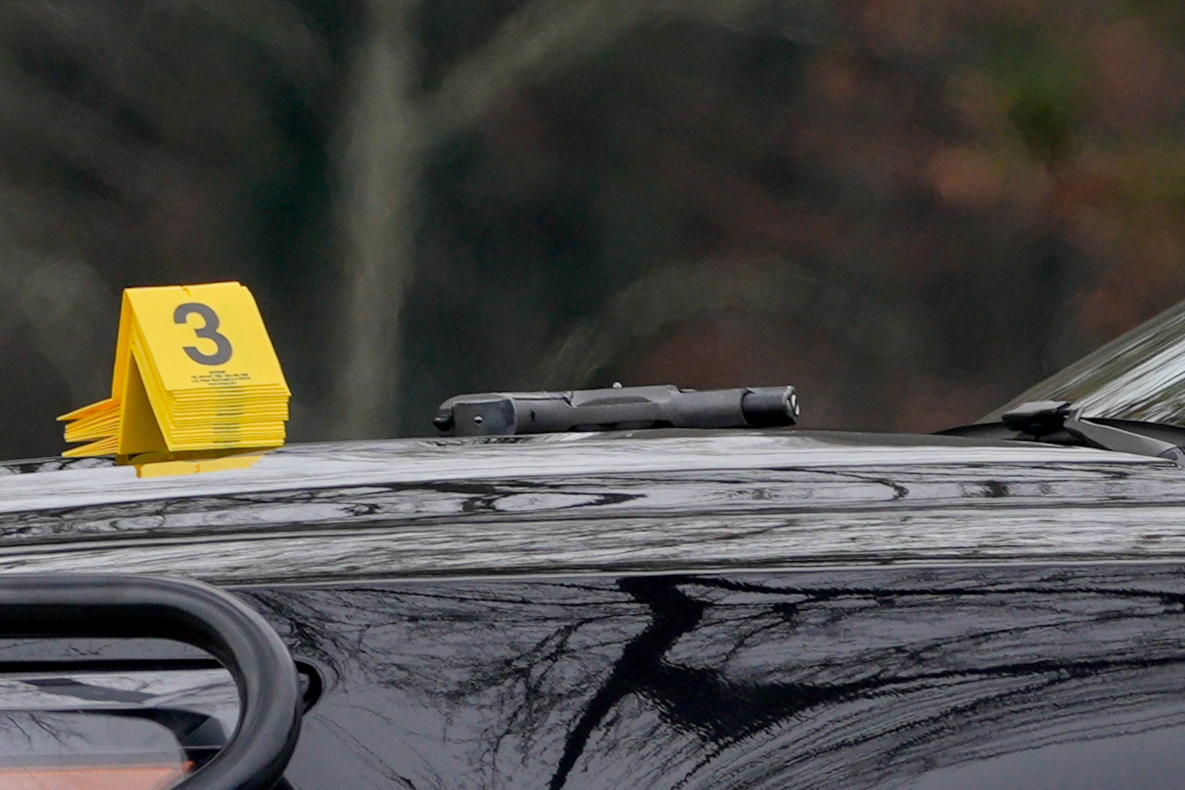 An evidence marker sits near a gun on the hood of a Sandy Springs police vehicle. (Ben Hendren for the AJC)