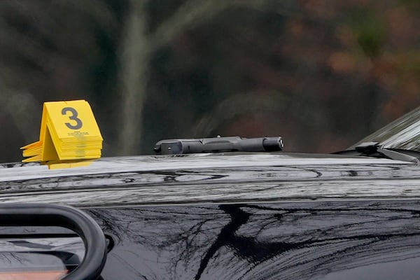 An evidence marker sits near a gun on the hood of a Sandy Springs police vehicle. (Ben Hendren for the AJC)