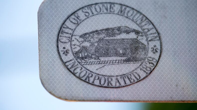 The city of Stone Mountain emblem is displayed on a street sign in downtown Stone Mountain. (ALYSSA POINTER/ALYSSA.POINTER@AJC.COM)