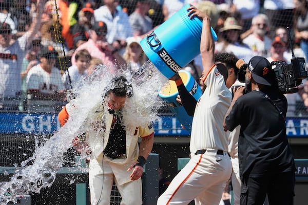 San Francisco Giants' Matt Chapman, left, is doused with water by Dominic Smith, second from right, after hitting a game-wining, two-run home run against the Atlanta Braves in the ninth inning of a baseball game Saturday, June 7, 2025, in San Francisco. (AP Photo/Godofredo A. Vásquez)